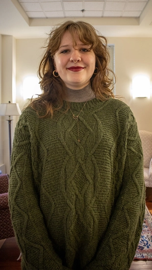 A female student standing in an office with two lamps on either side