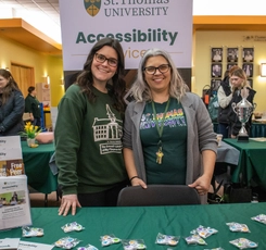 two women standing at a resource booth