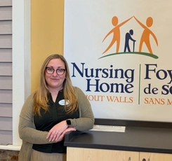 Ashley standing in front of Nursing Home Without Walls logo