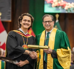 Student receiving his diploma from the president