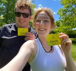 Liam MacDougall and Emily Lynch taking a selfie holding up Kingsbrae Conversations name tags