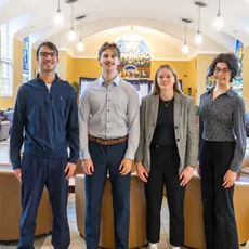 Group of Economics students standing and smiling in the Great Hall