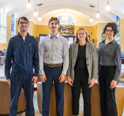 Group of Economics students standing and smiling in the Great Hall