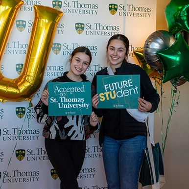 Two happy accepted students at Open House holding 