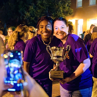 Two students holding the Cheer Off trophy