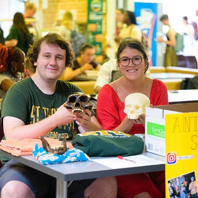 two anthro students holding skulls