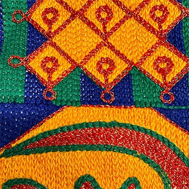 A woven piece of African textile in yellow, green, red and blue.