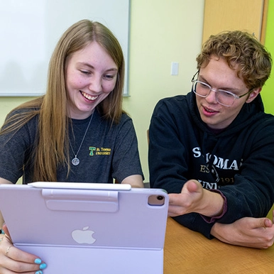students looking at tablet together