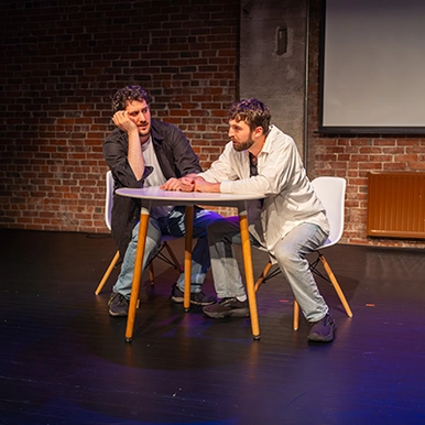 Two men acting at a table