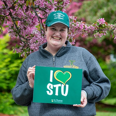 Student on campus in spring holding 