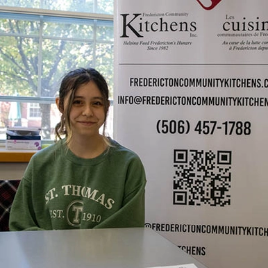 student manning a booth at the volunteer fair