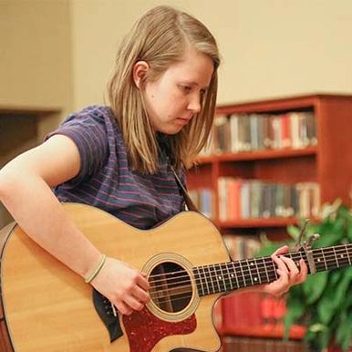 student playing guitar in George Martin Hall