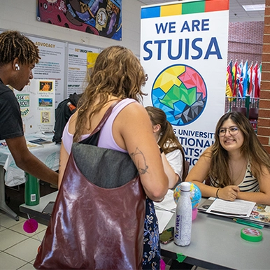 Students interacting at a booth at the clubs and societies fair