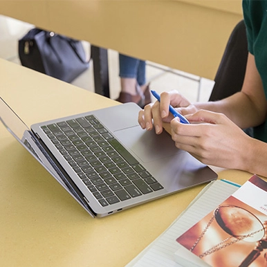 A students hands typing on a computer
