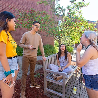 A group of 4 students talking outside residence