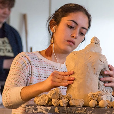 A student working on a clay sculpture