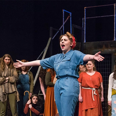 A student singing on a stage