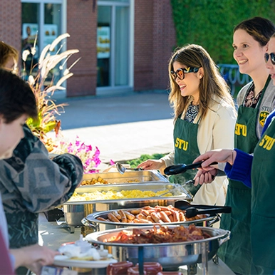 STU Staff serving breakfast to students