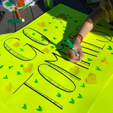 Student making a Go Tommies sign