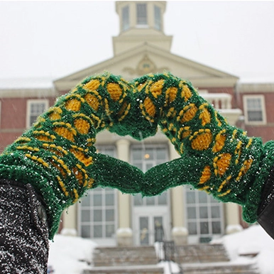 Person wearing STU Mitts making a heart in front of GMH