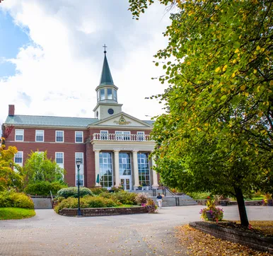 George Martin Hall behind trees on campus with leaves that are beginning to change colour