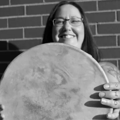 Holding a drum and smiling
