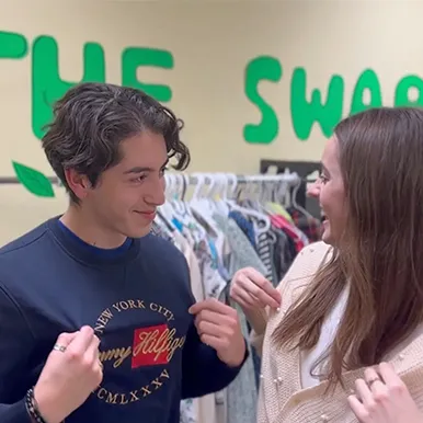 Two students showing off their sweaters from the clothing drive