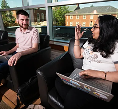 Students using laptops and talking