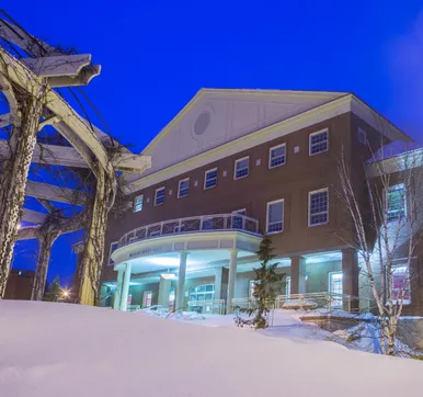 Photo of Brian Mulroney Hall at night in the winter 