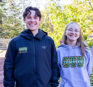 Students Brayden and Kaitlyn on campus wearing Tommies Swag