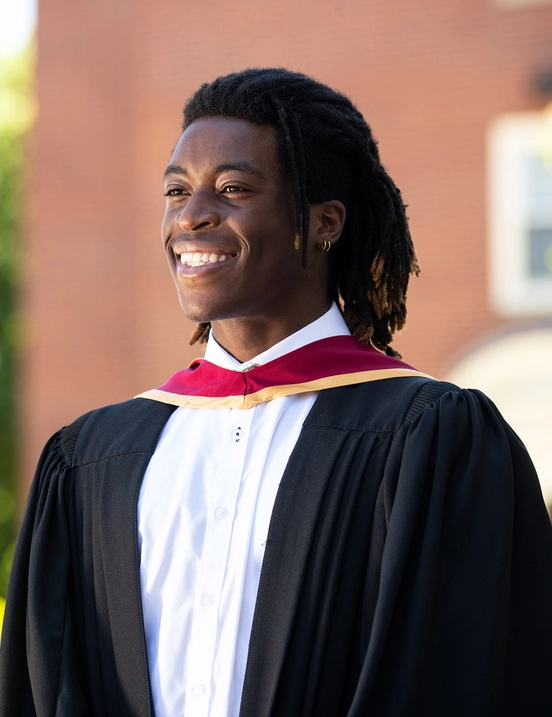 a photo of stu graduate with their gown on smiling