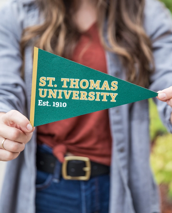 A female student holds out a STU pennant