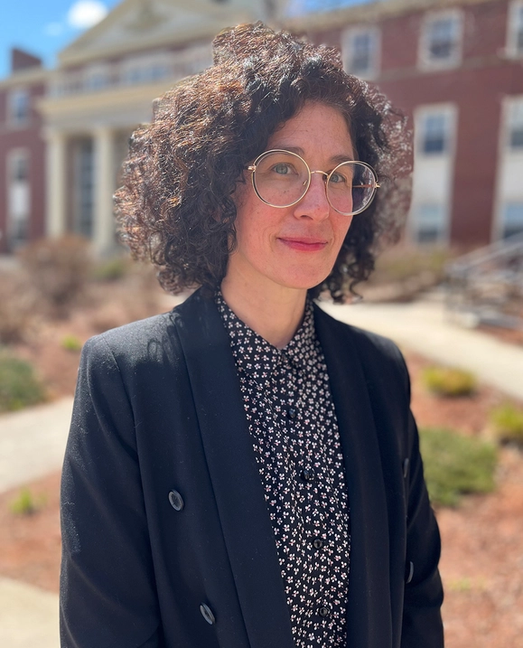 A photo of STU professor Kristi Allain standing outside on campus