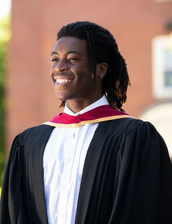 a photo of stu graduate with their gown on smiling