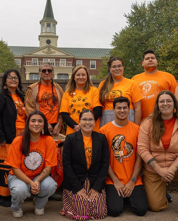 The Indigenous Student Services staff stand in front of George Martin Hall wearing orange shirts during an Every Child Matters ceremony