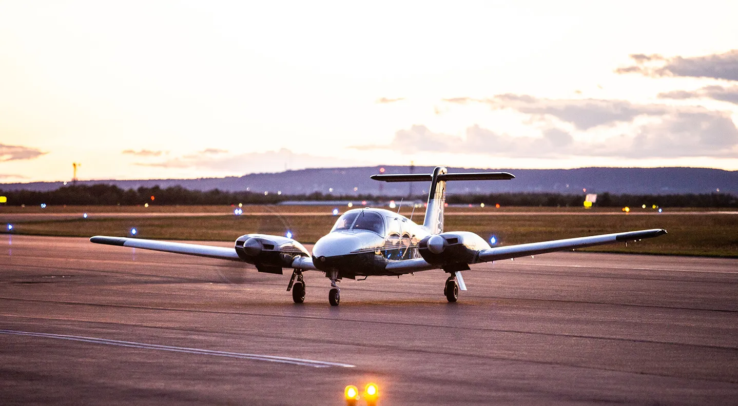 A small plane in front of the skyline at dusk