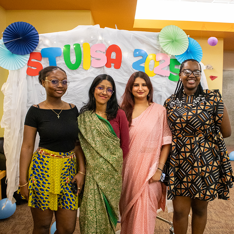 A group of four female students wearing their traditional dresses at the Multicultural Fair