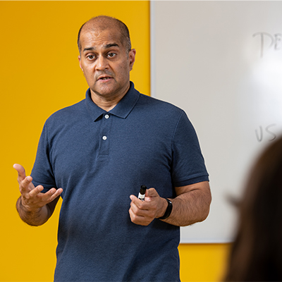 Professor in front of whiteboard, teaching in classroom