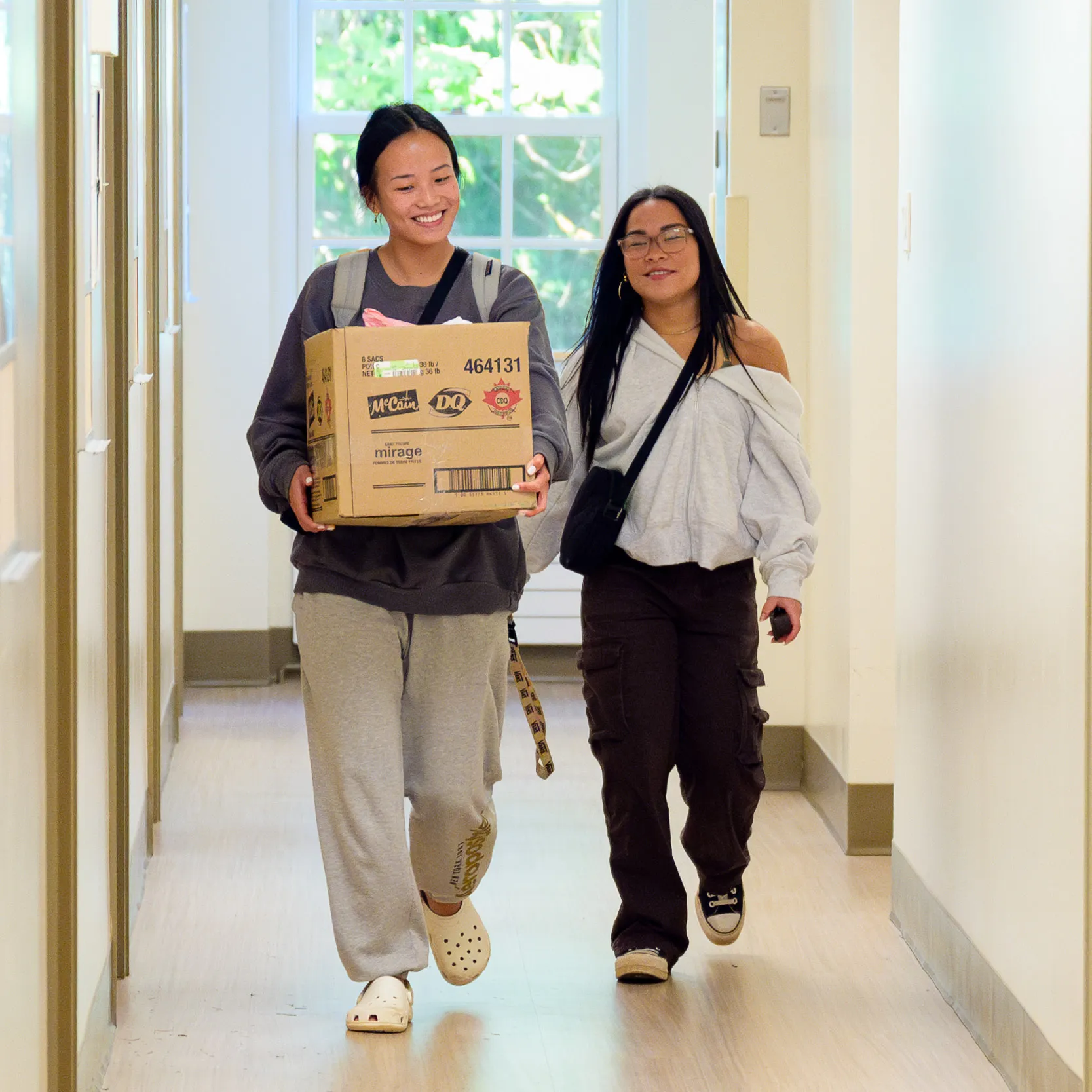 Students holding moving boxes