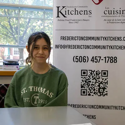 student manning a booth at the volunteer fair