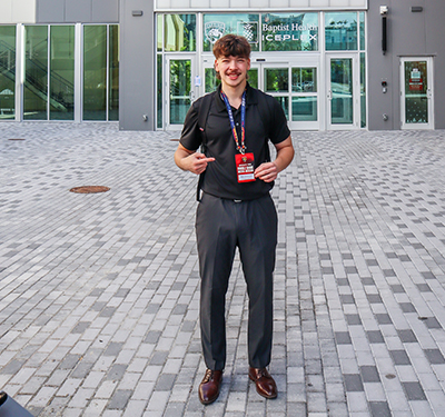 Journalism and Digital Media and Creative Arts Student Aiden standing in front of Baptist Health IcePlex in Fort Lauderdale