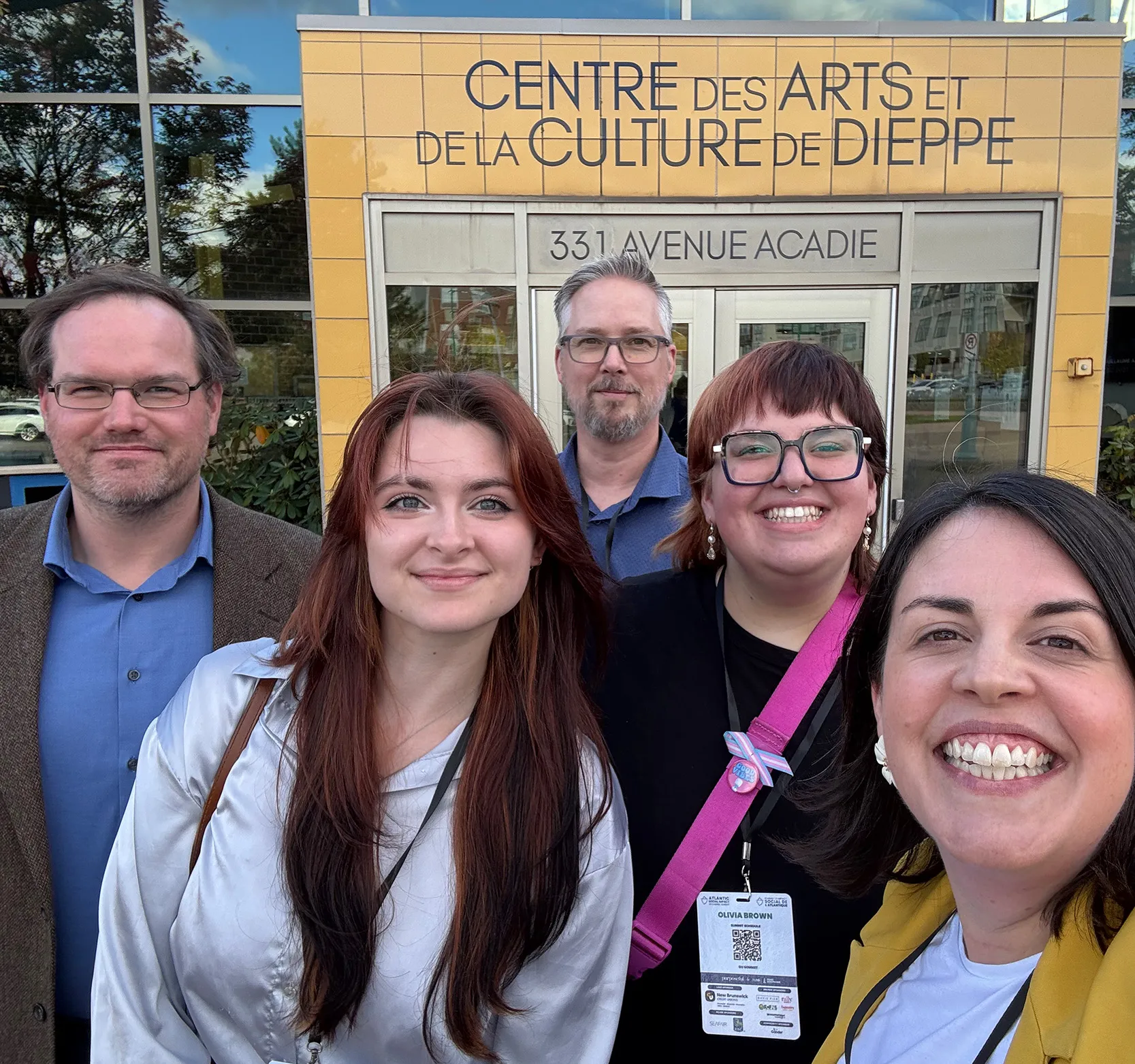 Dr. Brennan Lowery stands outside the Centre des Arts et de Culture Dieppe with a group of students
