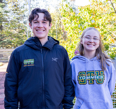 Students Brayden and Kaitlyn on campus wearing Tommies Swag
