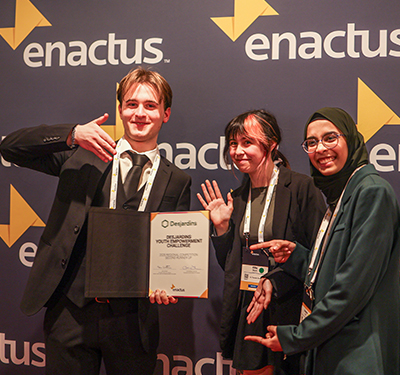 Picture of three Enactus STU members holding award at regional exposition