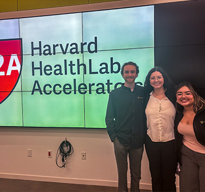 three students standing in classroom at Harvard