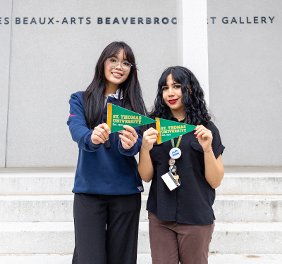 Laura Thai and Charlotte James at the Beaverbeook Art Gallery holding 91̽ pennants